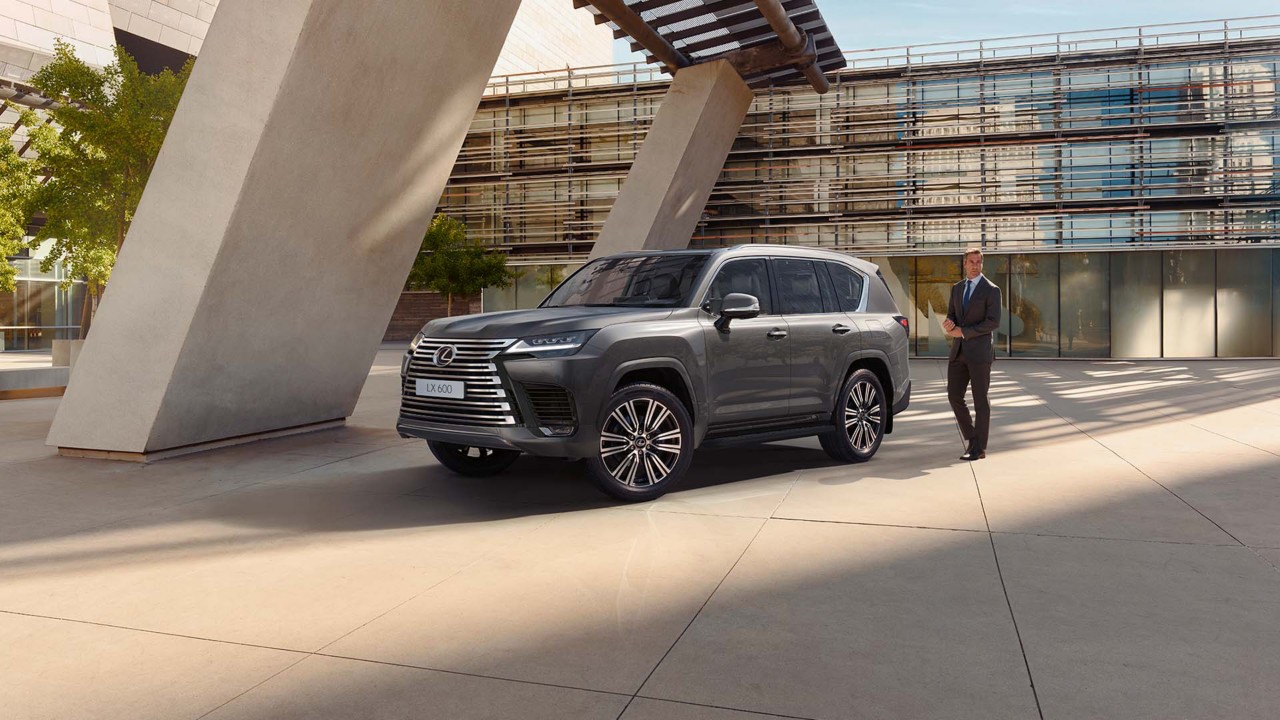 A man standing next to a Lexus LX 