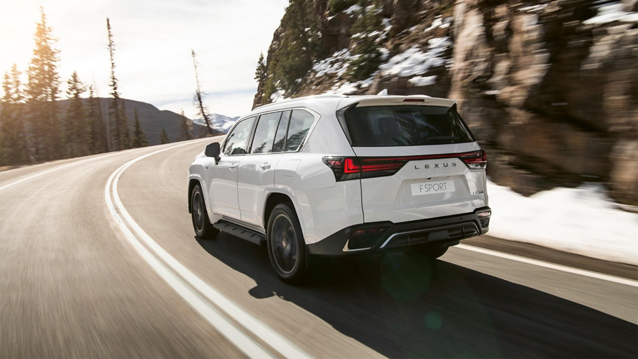 Rear view of the Lexus LX driving in a mountainous location