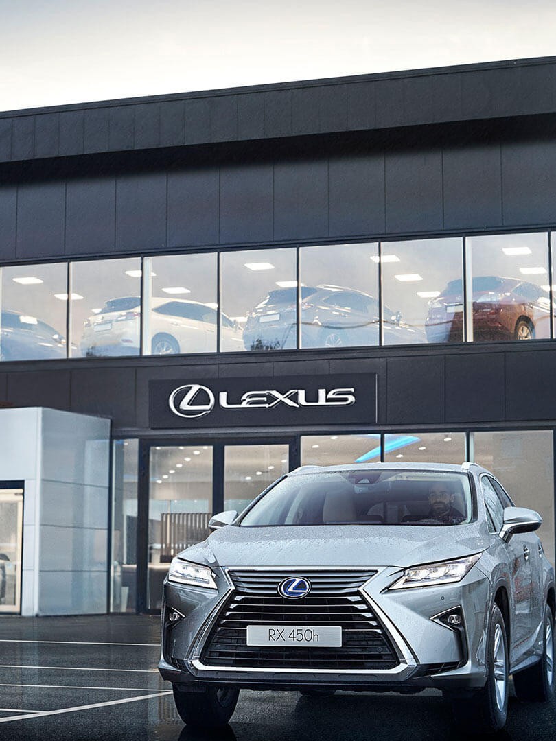 A Lexus RX 450h parked outside a Lexus dealership 